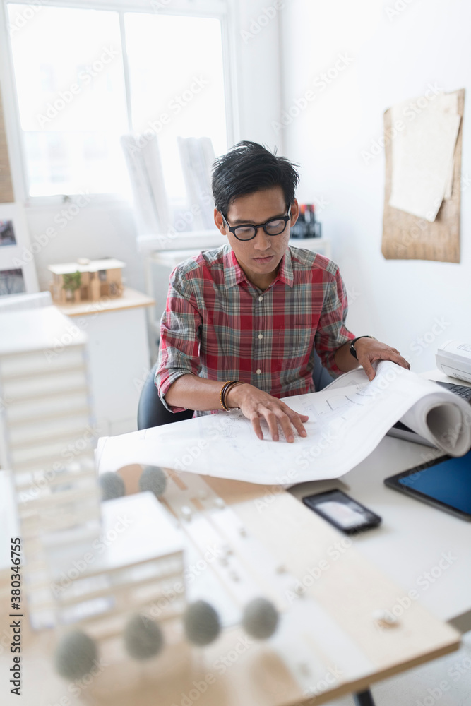 Architect looking at blueprints in office Architect looking at blueprints in office
