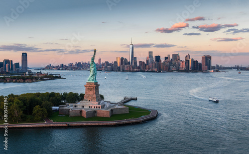 Aerial view of city with Statue of Liberty at sunset