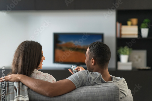 Couple sitting in living room and watching TV photo