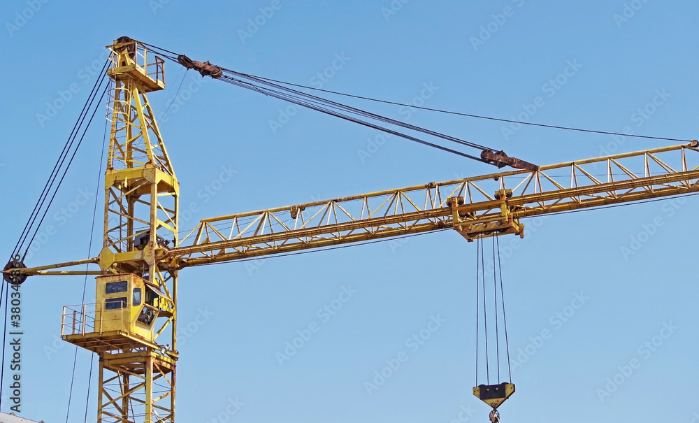 yellow construction crane tower on background sky