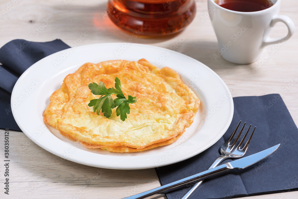 Breakfast of scrambled eggs with cheese (omelette with cheese) is on a white plate. Concept healthy food.