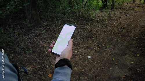 Walking in the forest, hiking trail, smart android navigation app in hand -  4k footage