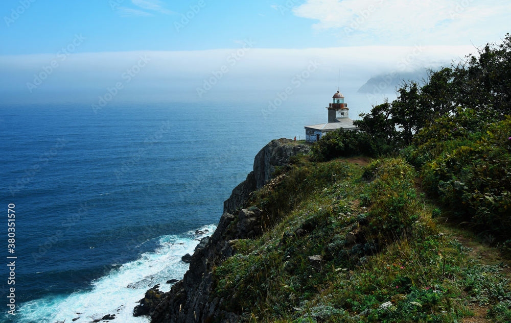 Old lighthouse located on the Pacific ocean. Beautiful scenery on a Sunny day.