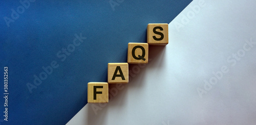 Concept word 'FAQS' on cubes on a beautiful white and blue background. Business concept. Copy space.