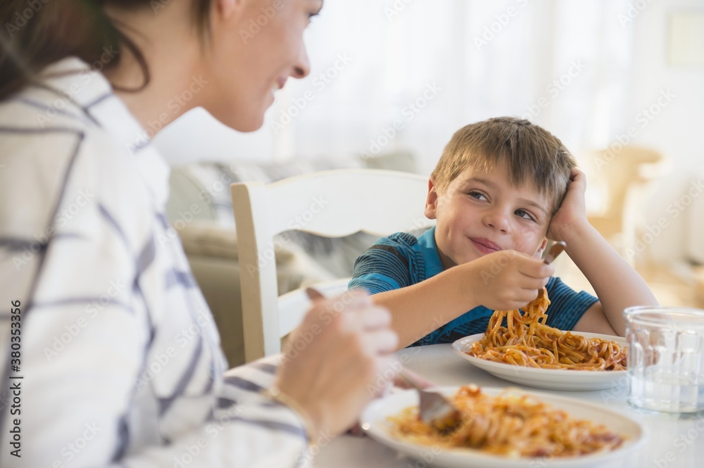 Mother and son (6-7) eating spaghetti Mother and son (6-7) eating spaghetti