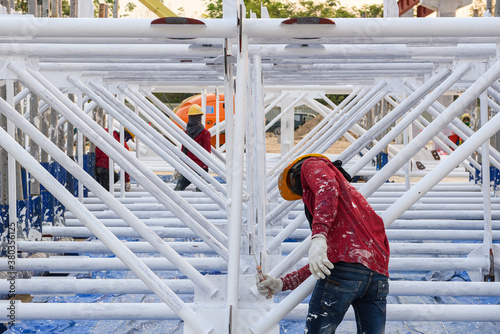 Canvas Print Workers are fireproof painting steel structure roof truss before lifting to inst