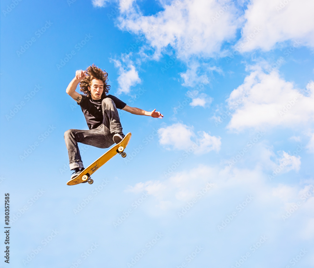 Man jumping on skateboard against sky and clouds Man jumping on skateboard against sky and clouds