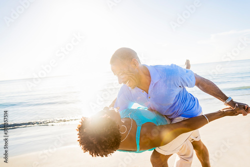 Mature couple dancing on beach photo