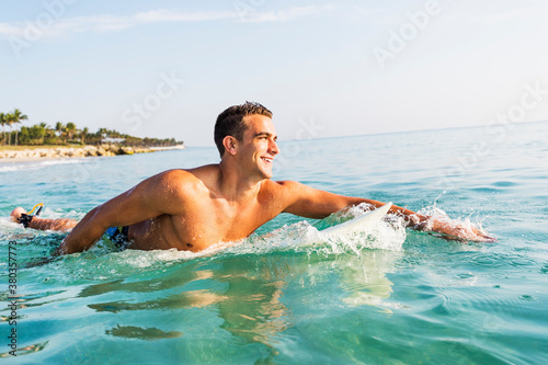 Young surfer paddling photo