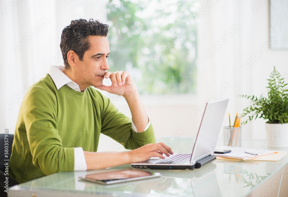 Portrait of man working on laptop at home Portrait of man working on laptop at home