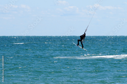 a man jumps on a kiteboard over the sea