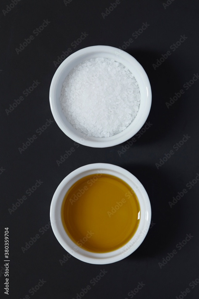 Olive oil and salt on black background Olive oil and salt on black background