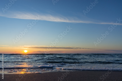 Sunset over the sea. Reflection of sunlight in the sea waves. The sky in the sunset rays.
