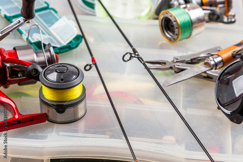 Different fishing tacles with lures and reels on wooden brown background with place for text. Different fishing tacles with lures and reels on wooden brown background with place for text.