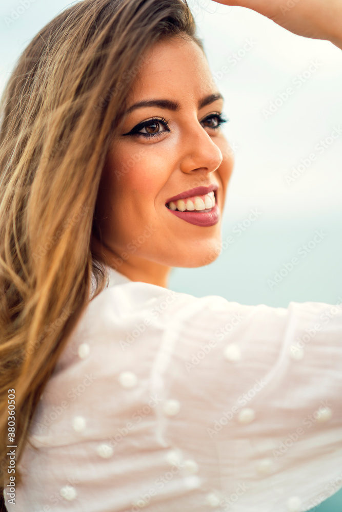 Chica con blusa blanca y bonita sonrisa en un acantilado Chica con blusa blanca y bonita sonrisa en un acantilado