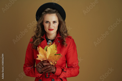 stylish woman in coat and beret isolated on beige background