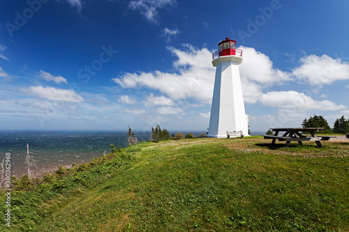 Cape George Lighthouse on green seaside cliff photo