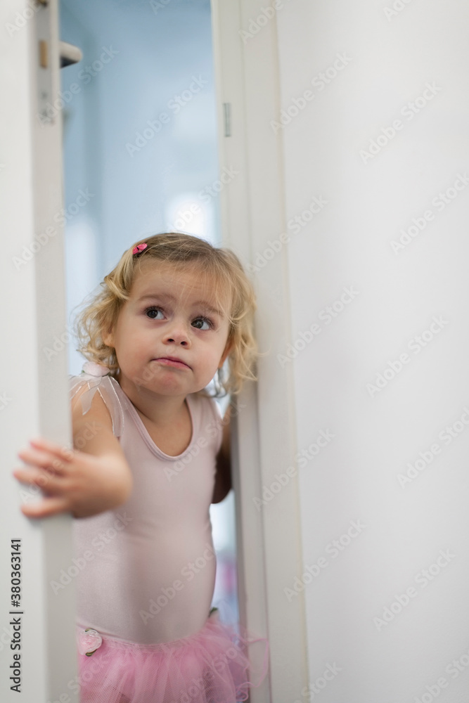 Girl (2-3) in pink skirt opening bedroom door Girl (2-3) in pink skirt opening bedroom door