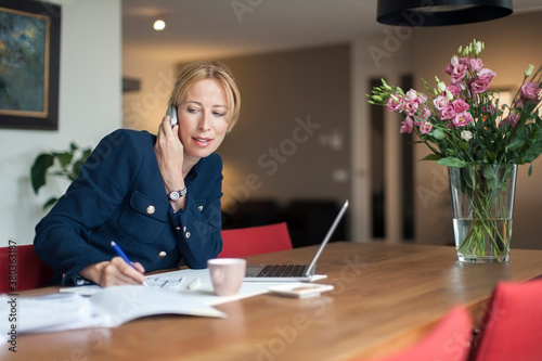 Woman talking on phone and making notes