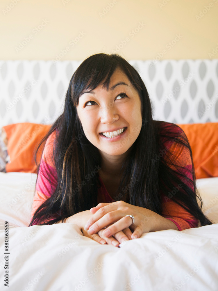Portrait of mid adult woman laying on bed Portrait of mid adult woman laying on bed