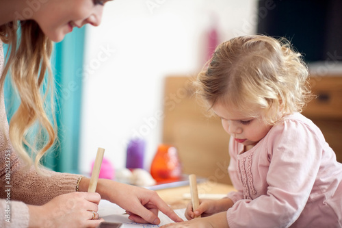 Woman teaching young girl at home