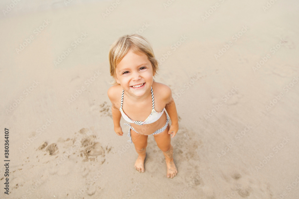 Smiling girl (2-3) on sandy beach Smiling girl (2-3) on sandy beach