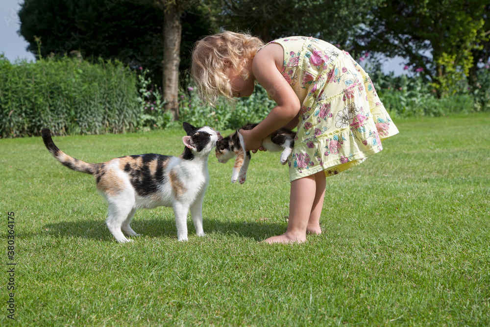 Little girl (2-3) playing with cats in garden Little girl (2-3) playing with cats in garden