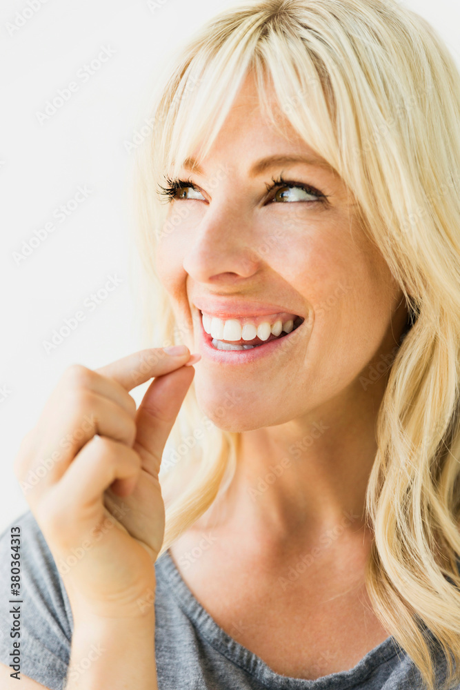 Studio portrait of blonde woman taking pill Studio portrait of blonde woman taking pill