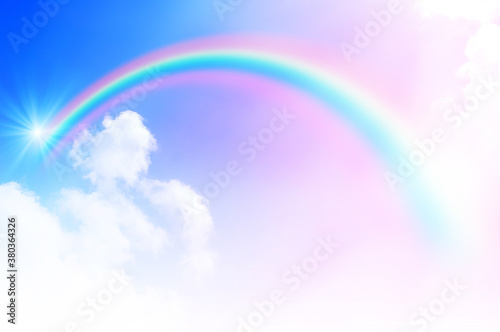 The Rainbow sky is Colorful sky with Soft clouds and a rainbow crossing. Fantasy magical sunny sky pastel background is fluffy white cloud. Freedom wallpaper concept. Sweet color dream.