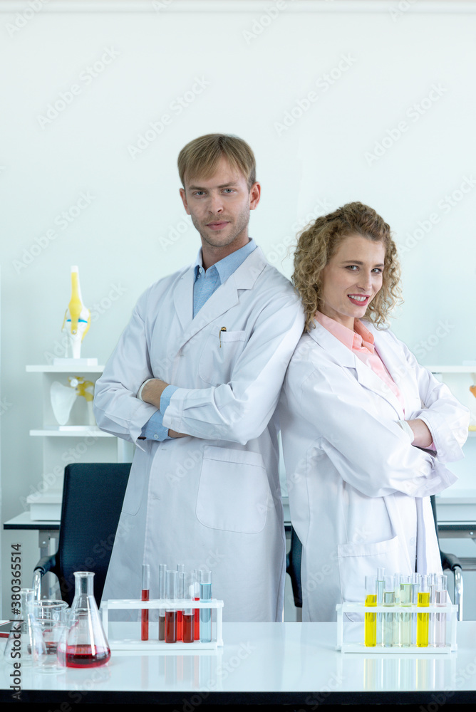 Two scientists stood confidently with folded arms before the experiment began. Two scientists stood confidently with folded arms before the experiment began.