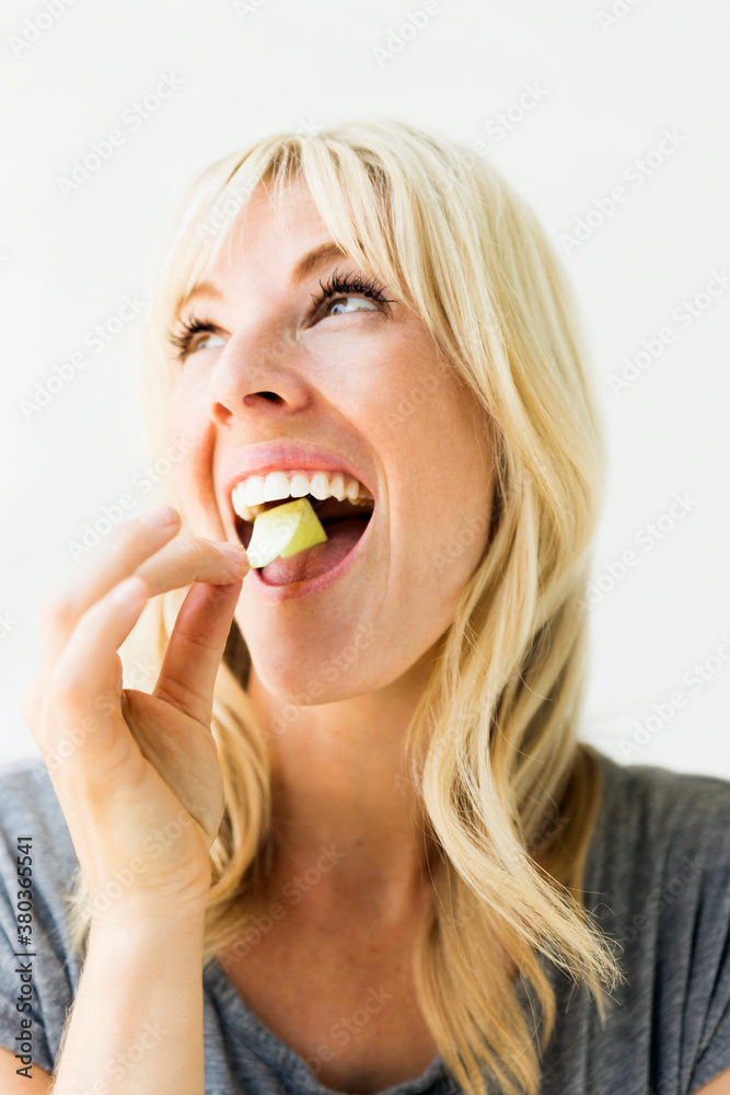 Studio portrait of blonde woman eating bubble gum Studio portrait of blonde woman eating bubble gum