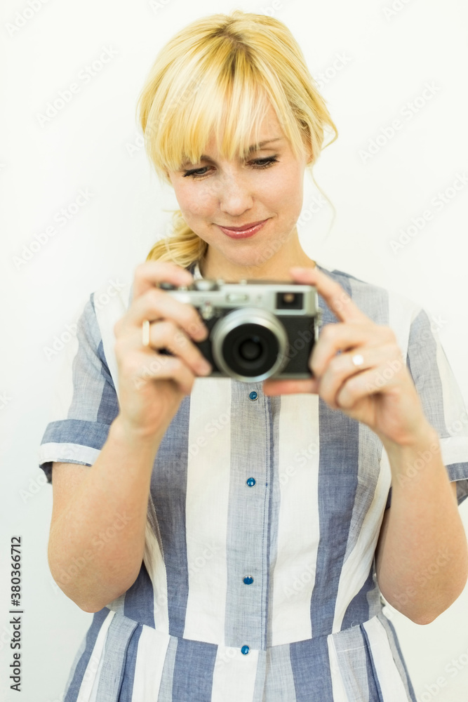 Studio shot of woman holding camera Studio shot of woman holding camera