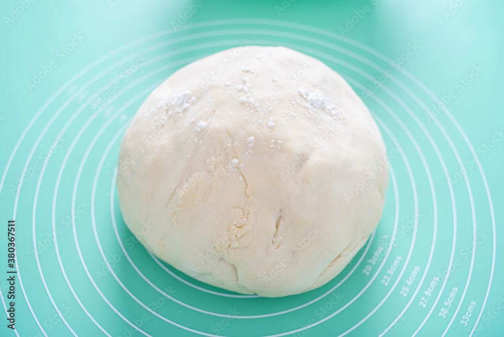 A lump of dough on a silicone kneading mat A lump of dough on a silicone kneading mat