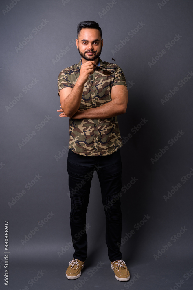 Fototapeta premium Young bearded Indian man against gray background