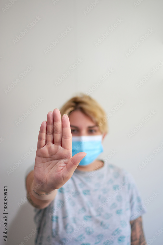 Girl wearing mask for protection from disease and show stop hands gesture for stop corona virus outbreak. Selective focus Girl wearing mask for protection from disease and show stop hands gesture for stop corona virus outbreak. Selective focus