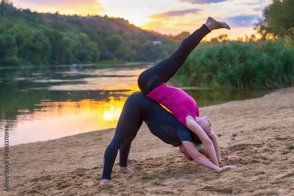 Fototapeta premium Fit young women performing acrobatics yoga