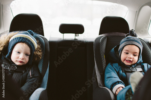 Two little boys in carseats in the their snowsuits photo