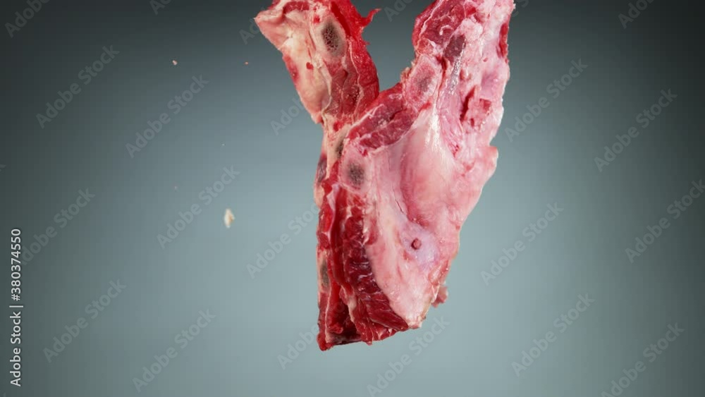 Flying piece of raw pork ribs hitting up in the air. Filmed on high speed cinema camera, 1000 fps.