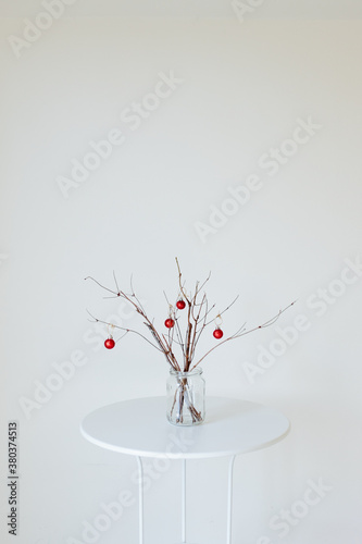 Minimal holiday decor of branches with red ornaments photo