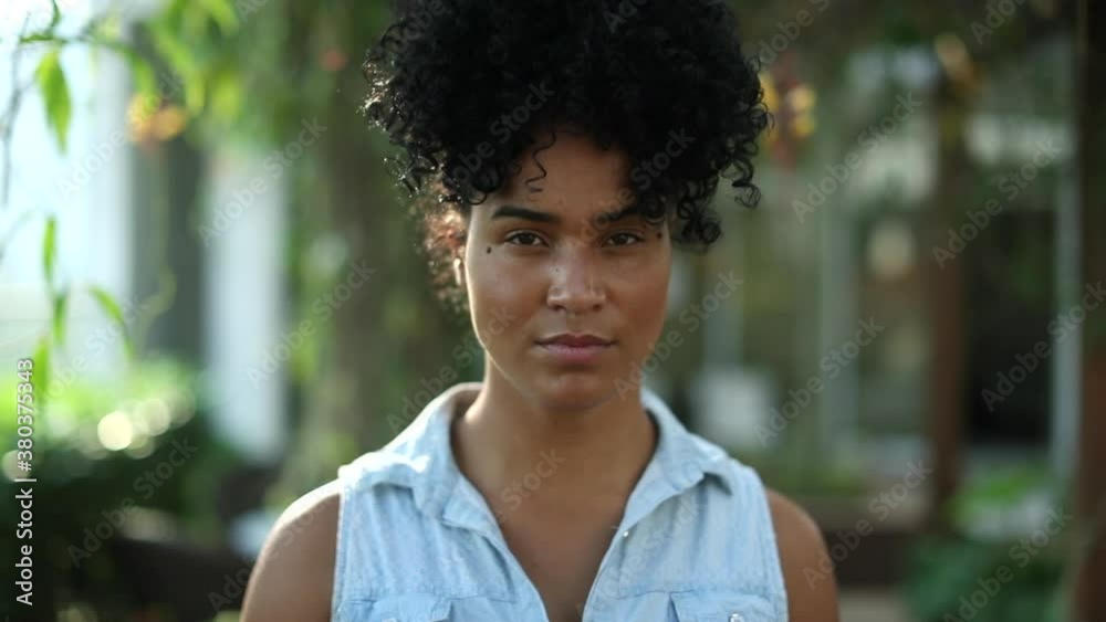 Confident young black woman walking forward. Serious African mixed race girl
