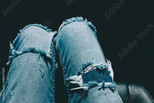 Woman's legs in frayed denim pants