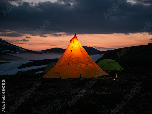 a tent of geologists glowing in the night in the mountains of the Kamchatka peninsula on the Bolshoi Semyachik volcano