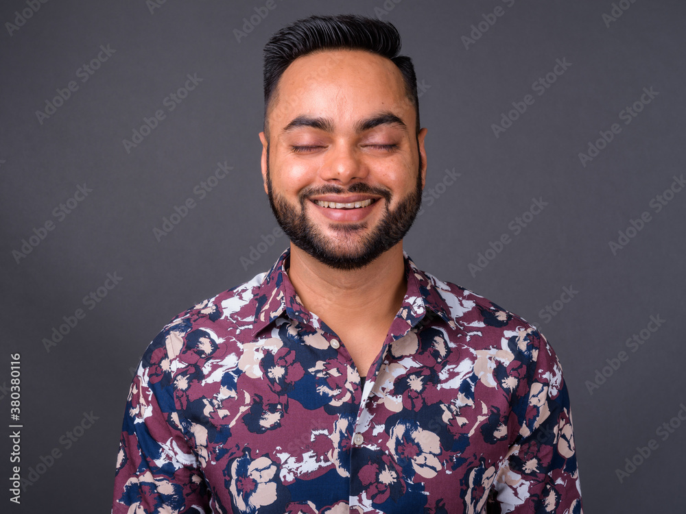 Fototapeta premium Young bearded Indian man against gray background