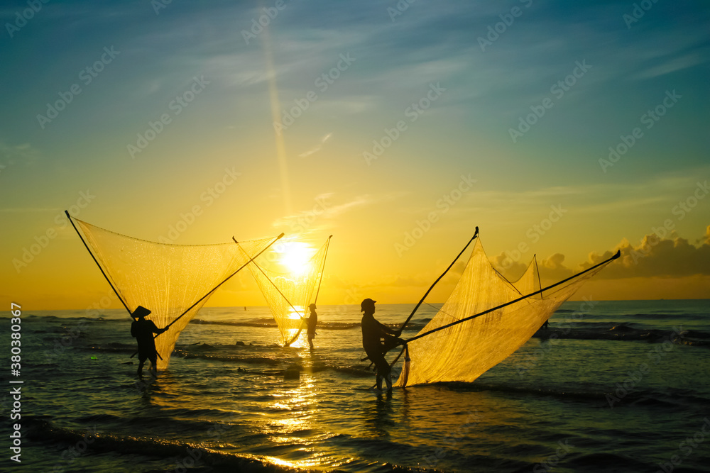 Fishermen repairing nets on a boat trip out to sea in the afternoon July 31, 2016 at the beach of Hai Ly, Vietnam.
