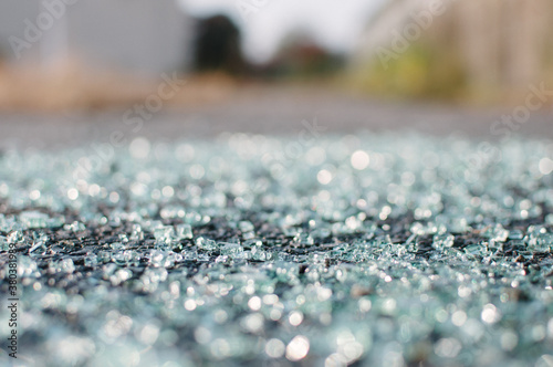 Close-up of shattered windshield glass on pavement