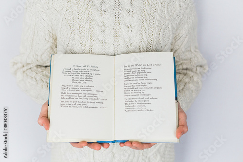 child holding a book of christmas songs