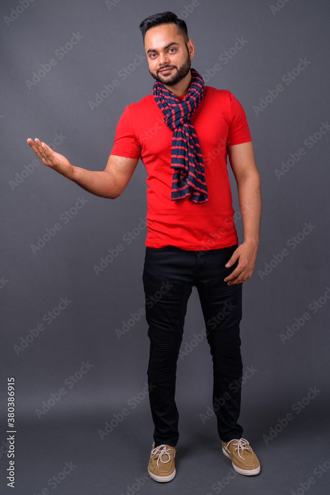 Young bearded Indian man against gray background Young bearded Indian man against gray background