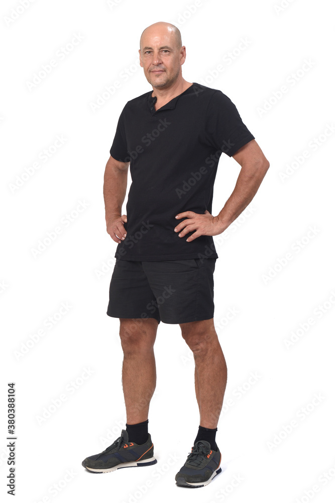 man wearing sportswear t-shirt and shorts on white background, hand on hip and looking at camera man wearing sportswear t-shirt and shorts on white background, hand on hip and looking at camera