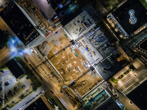 Aerial birds eye image of the office being built on a construction site at night in Vilnius. Long exposure.