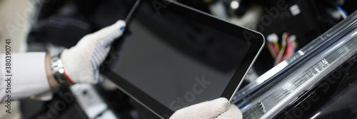 Fotografi Mechanic holding tablet to diagnose auto condition